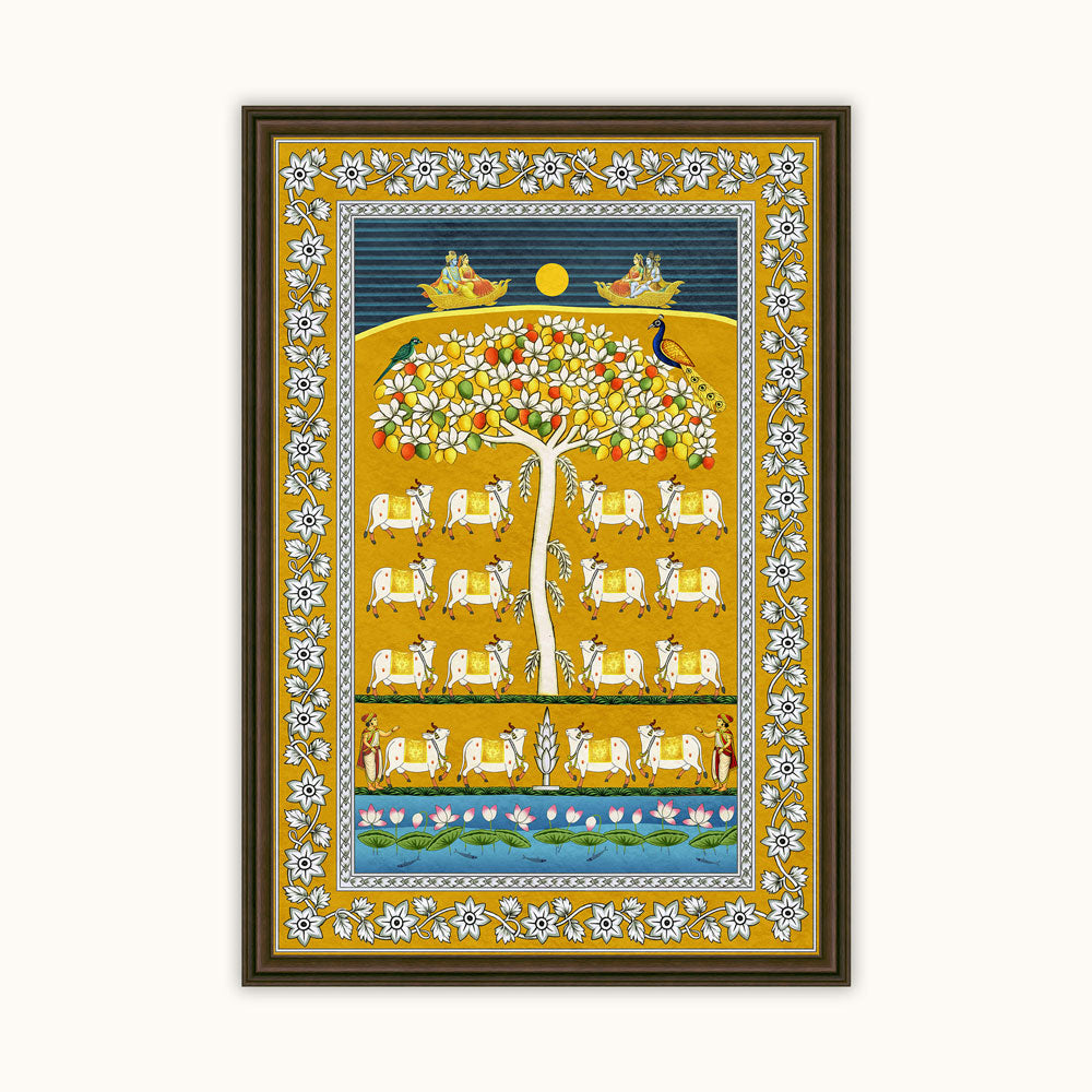 A framed Indian folk art print featuring a stylized tree of life with white cows, birds, and a yellow sun on a blue and gold background, enclosed in a dark brown frame.