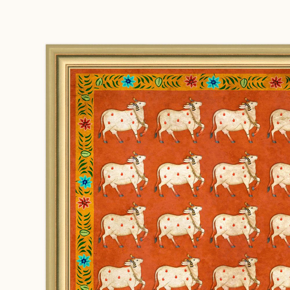 A framed art print featuring a repeating pattern of white cows with red spots on an orange background, bordered by a decorative green and blue floral frame.