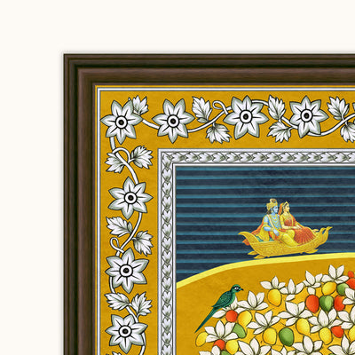 Close-up of a framed decorative art print showing a mustard-yellow border with white floral motifs, a blue striped inner panel, and a yellow lower section with flowers, fruit, and a small bird. The frame is dark brown.