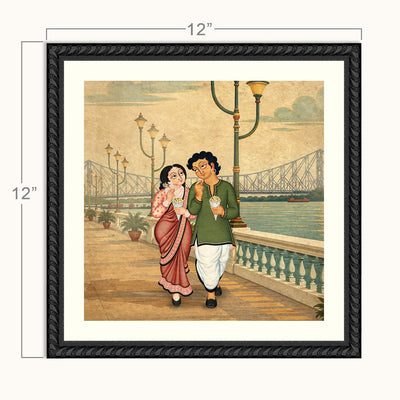 Framed square wall art showing a vintage-style illustration of a man and woman walking along a waterfront promenade with a Howrah bridge in the background. The artwork is presented in a black ornate frame with a white mat, and dimension labels indicate 12 inches by 12 inches.