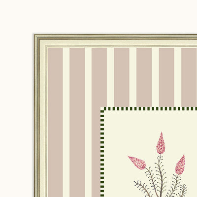 Close-up of a framed art featuring vertical taupe and cream stripes, a green checkered border, and pink floral illustrations.