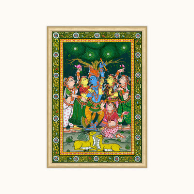A framed traditional Indian-style depicting a group of children and a blue-skinned deity under a tree, with an ornate green border and a light wood frame, shown against a plain off-white background.