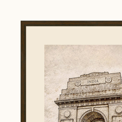 Framed art showing a close-up architectural section of India Gate in Delhi, with a beige textured background and a dark brown frame.