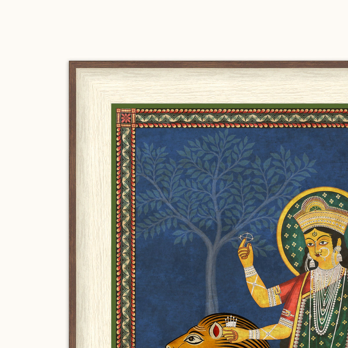 A framed Indian folk art depicting a deity with a cow, shown in a close-up view with a cream-colored mat and a brown wooden frame against a white background.