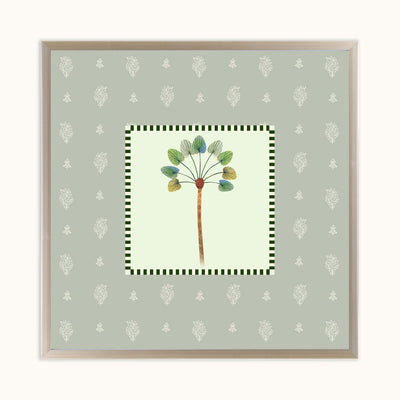 A square framed art featuring a botanical illustration of a dandelion-like plant with green and blue-green leaves on a pale yellow center panel, surrounded by a green-and-white checkered border and a sage green patterned background. The print is housed in a light wood frame and displayed against a clean off-white background.
